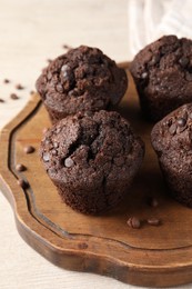 Photo of Delicious fresh chocolate muffins on white table, closeup