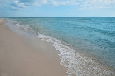 Sea waves rolling onto sandy tropical beach