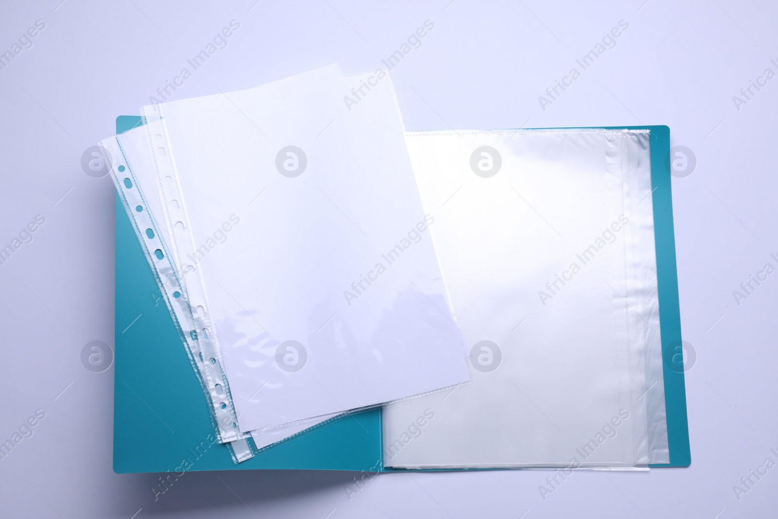 Photo of File folder with punched pockets and paper sheets isolated on white, top view