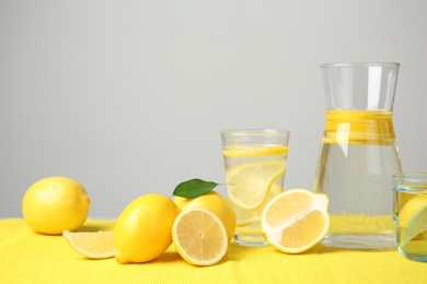 Photo of Composition with lemon water and fresh fruits on table