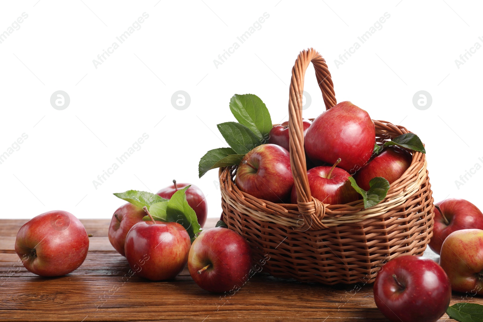 Photo of Ripe red apples and leaves on wooden table against white background