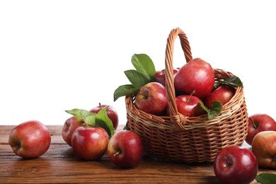 Ripe red apples and leaves on wooden table against white background