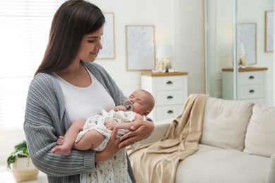 Mother holding her sleeping baby at home