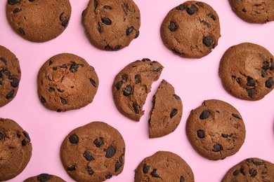 Delicious chocolate chip cookies on color background, flat lay