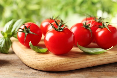 Photo of Board with fresh cherry tomatoes on wooden table