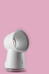 Modern white electric fan on pink background