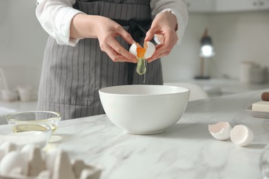 Photo of Woman making dough at table in kitchen, closeup