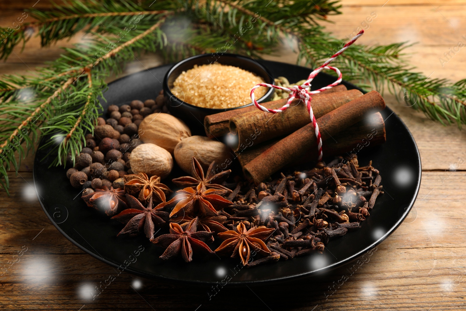 Image of Different spices and fir tree branches on wooden table. Cinnamon, anise, cloves, allspice, nutmegs, brown sugar, cardamom