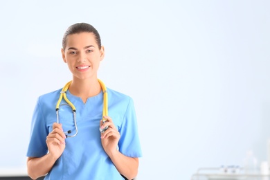 Portrait of young medical assistant with stethoscope in hospital. Space for text