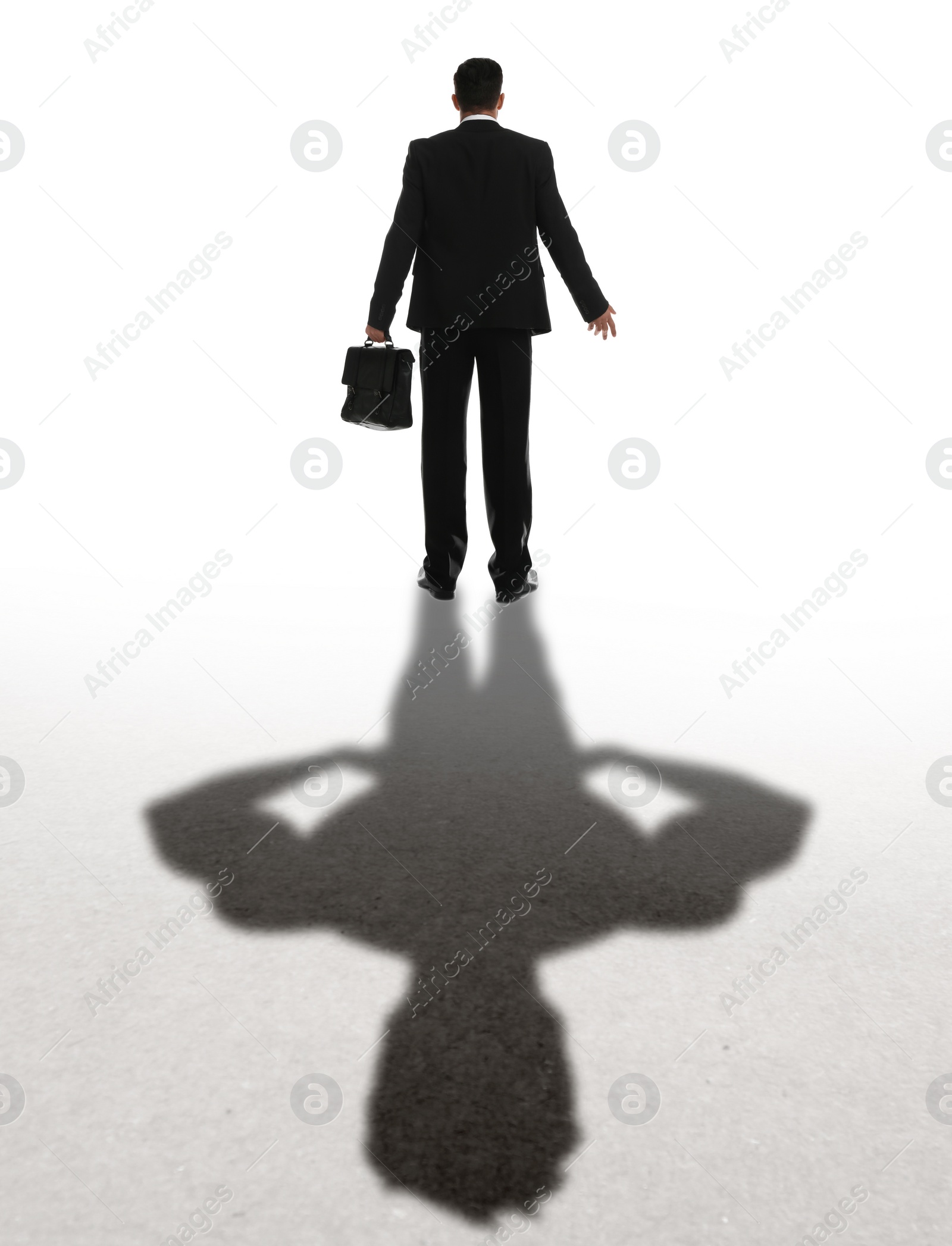 Image of Businessman and shadow of strong muscular man behind him on white background. Concept of inner strength