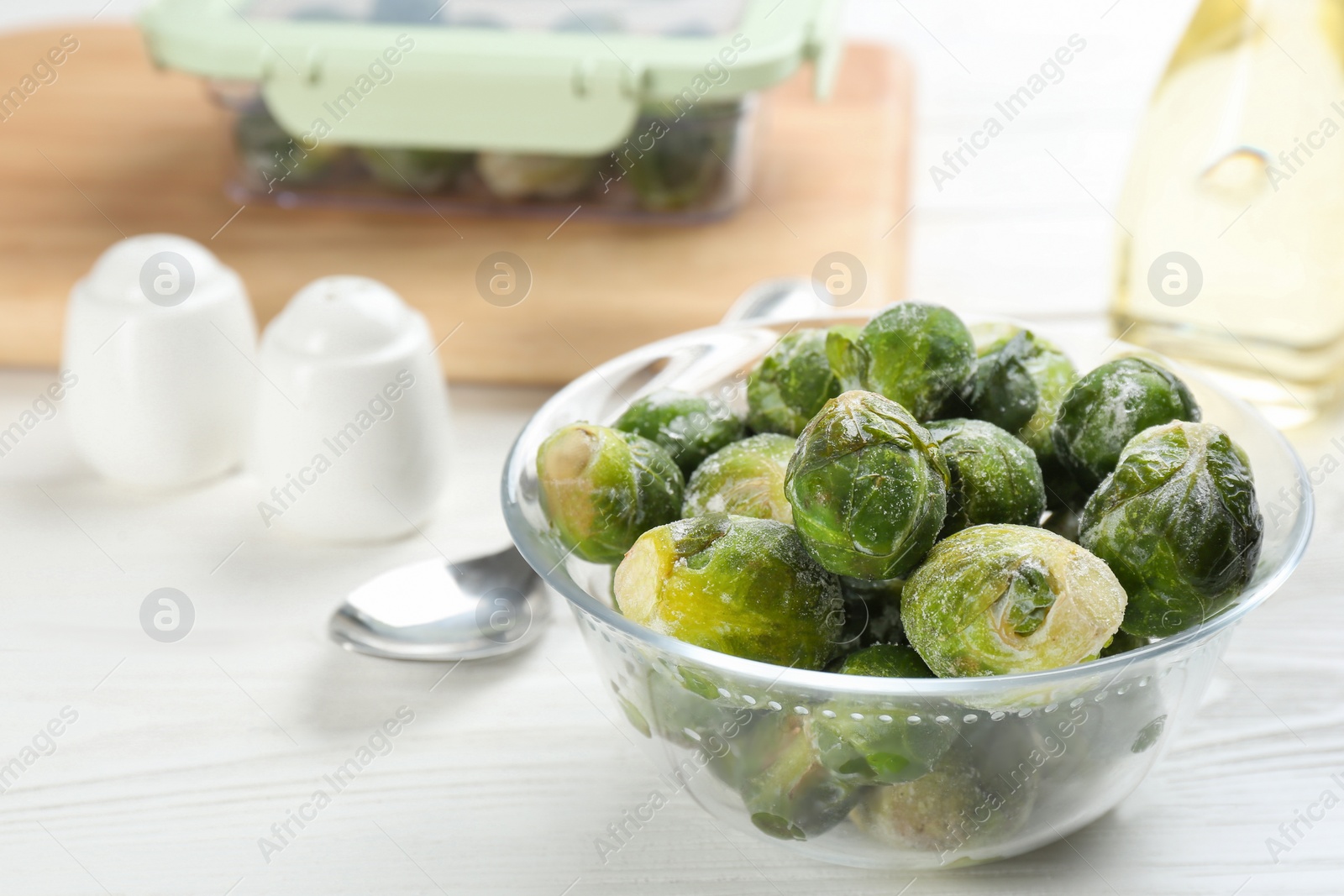 Photo of Frozen Brussels sprouts on white wooden table. Vegetable preservation