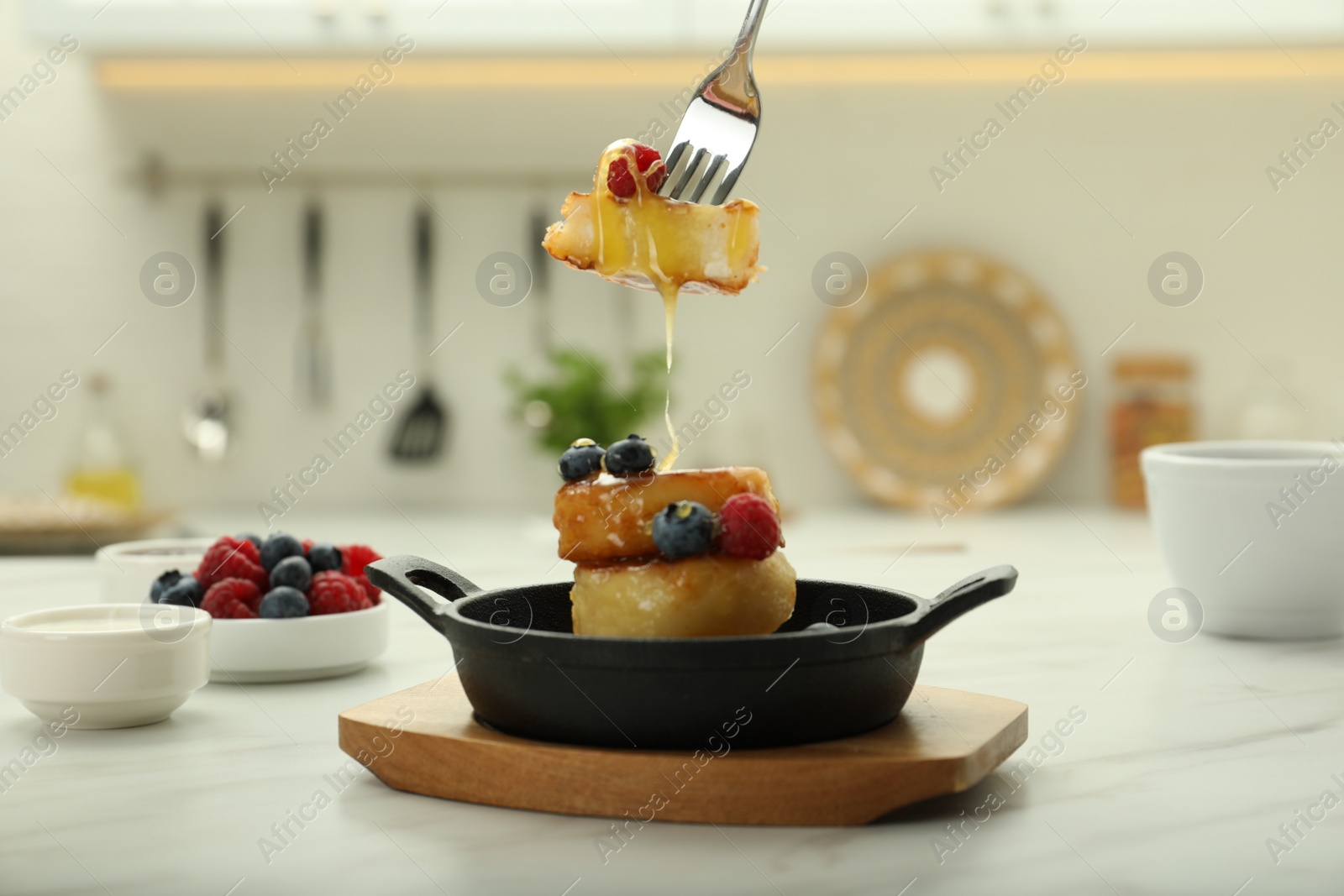 Photo of Delicious cottage cheese pancakes with fresh berries and honey served on white table