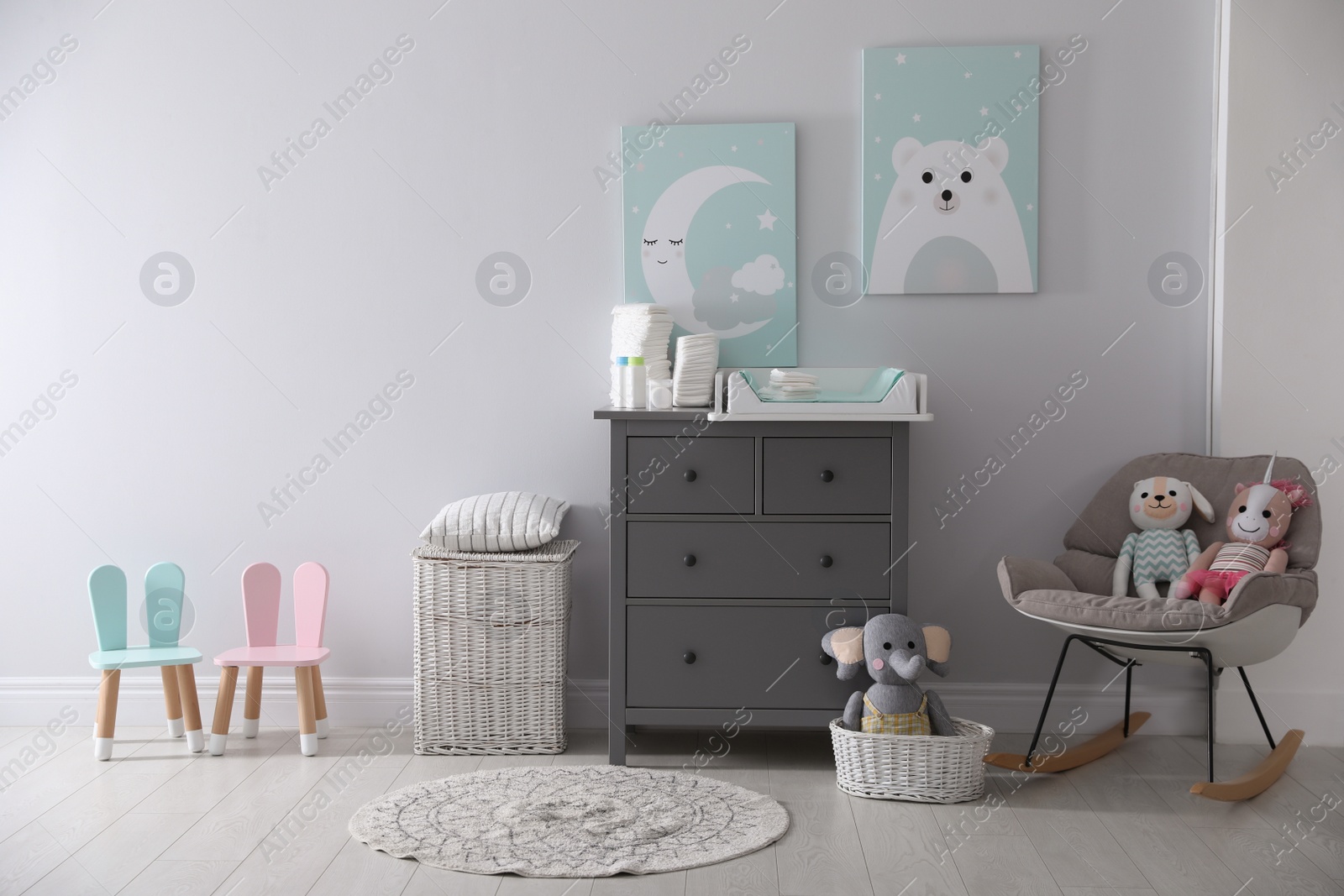 Photo of Chest of drawers with changing tray and pad in baby room. Interior design