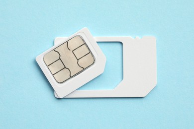 Modern SIM card on light blue background, top view