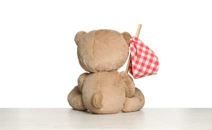 Photo of Cute teddy bear with checkered flag isolated on white, back view