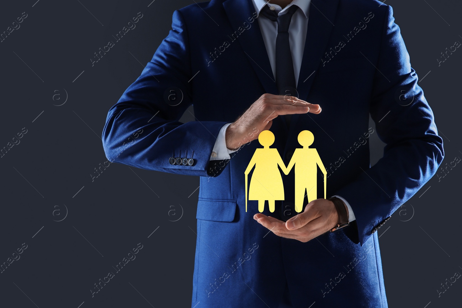 Image of Man demonstrating image of elderly couple on grey background, closeup. Retirement concept