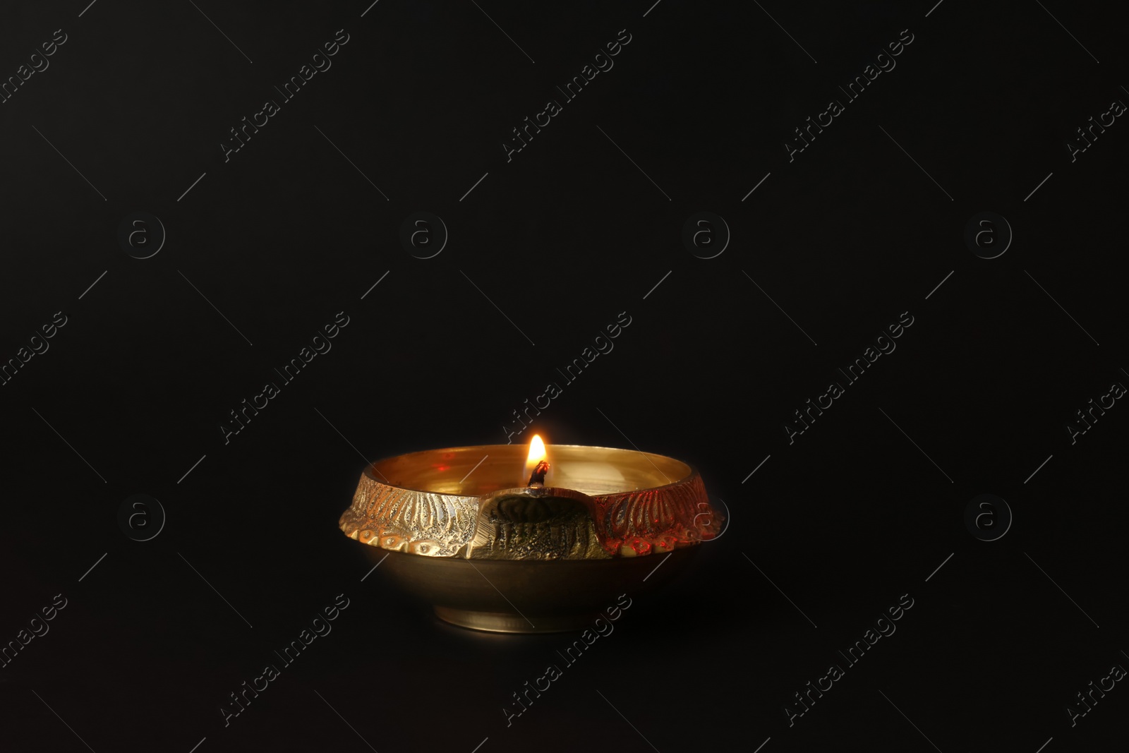 Photo of Lit diya lamp on black background. Diwali celebration