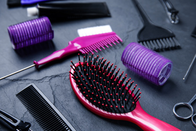 Photo of Professional tools for hair dyeing on black stone background