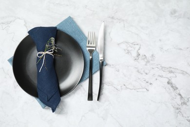 Photo of Stylish setting with elegant cutlery on white marble table, top view. Space for text