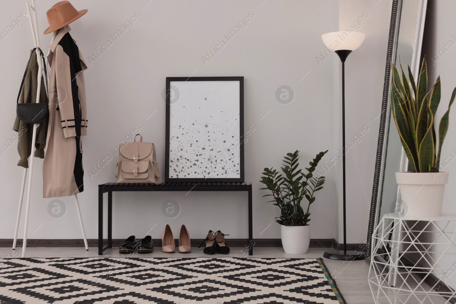 Photo of Stylish hallway room interior with bench, shoes, clothes rack and floor mirror