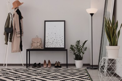 Stylish hallway room interior with bench, shoes, clothes rack and floor mirror