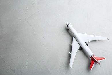 Toy airplane on grey stone background, top view. Space for text