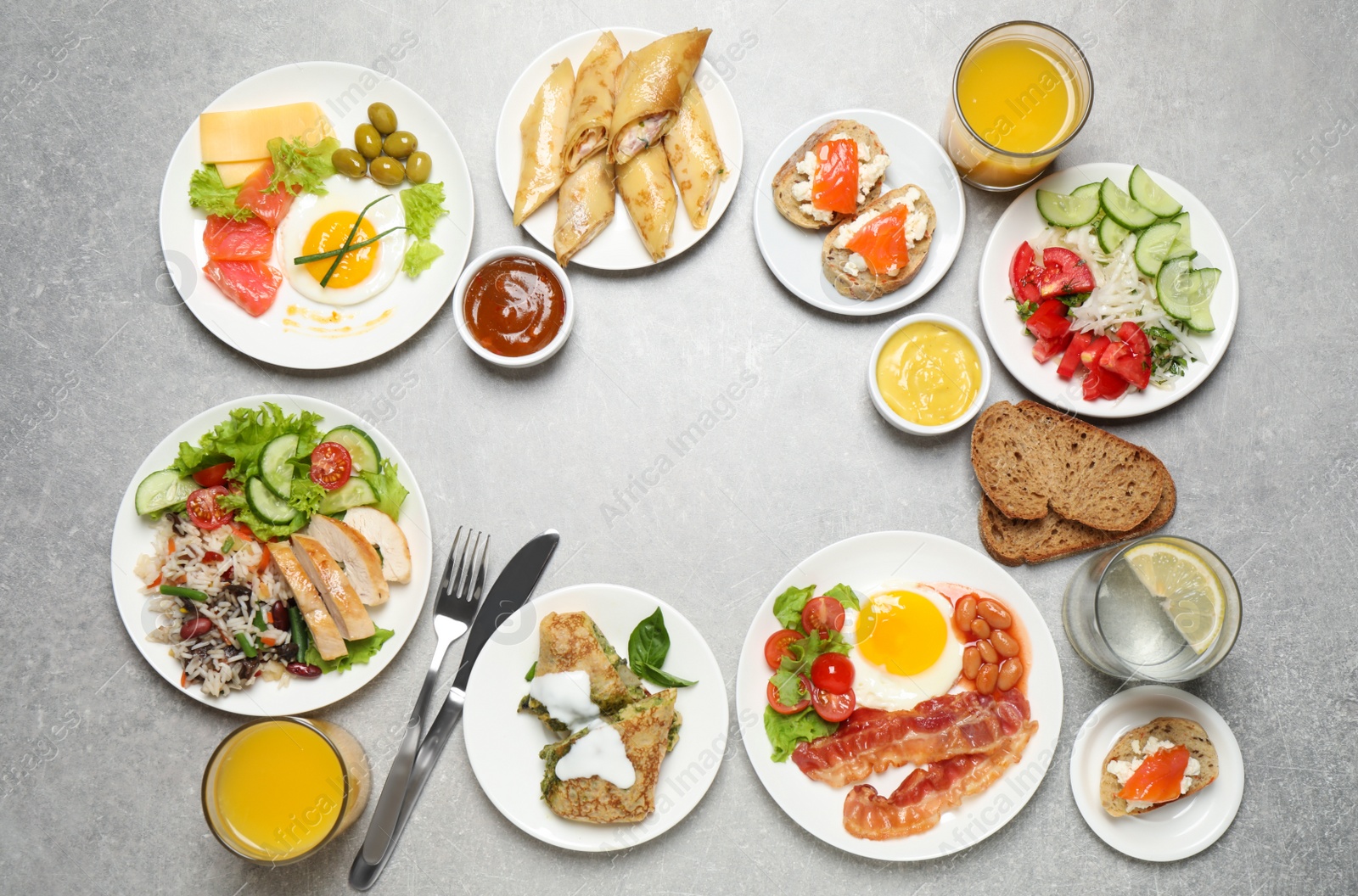 Photo of Buffet service. Frame of many different dishes on light grey table, space for text