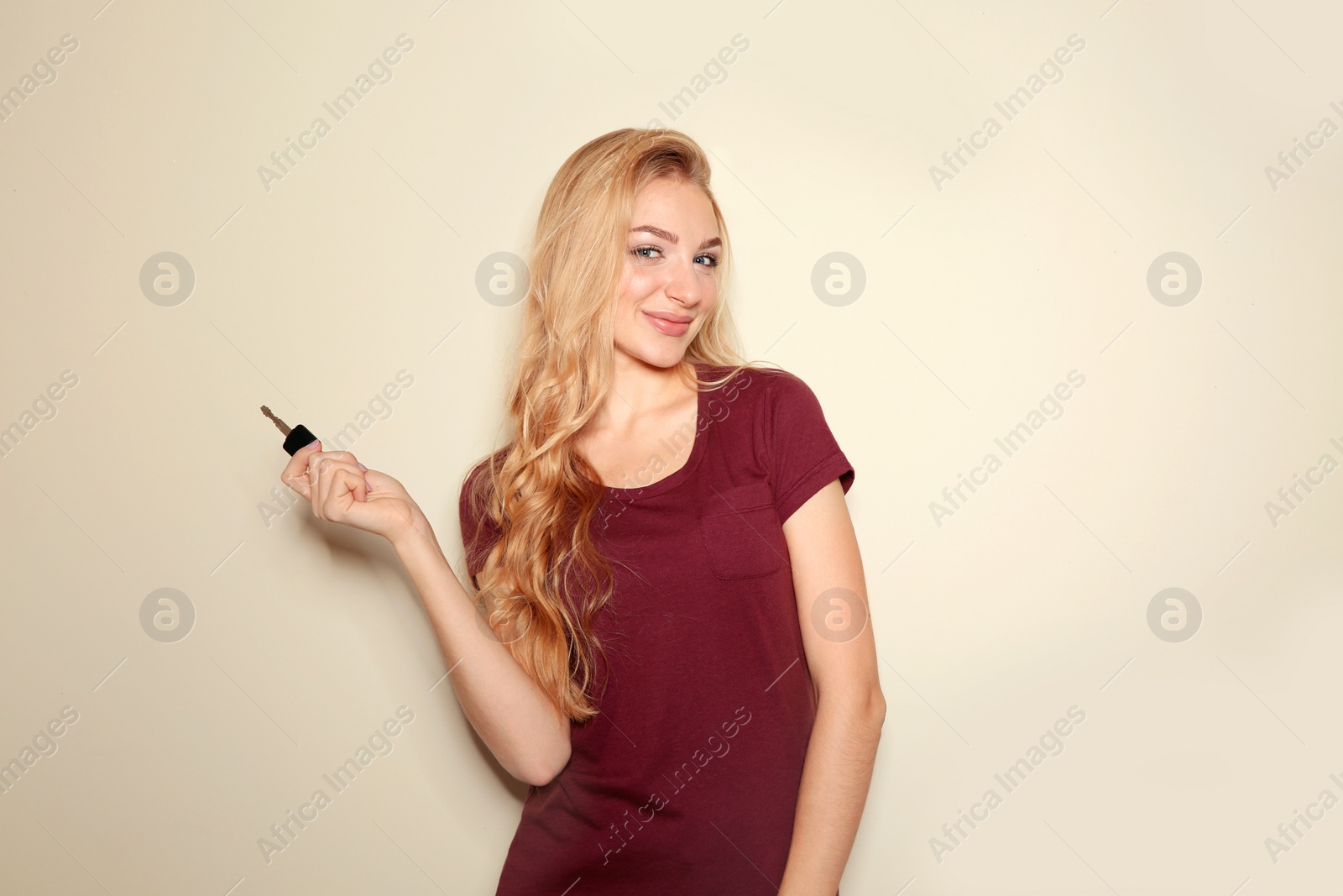 Photo of Happy young woman with car key on color background. Getting driving license