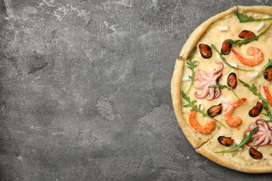 Delicious seafood pizza on grey table, top view. Space for text