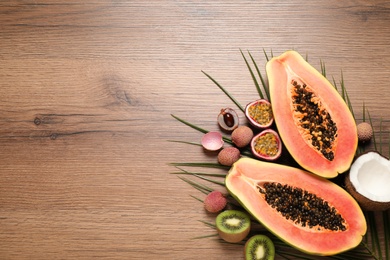 Photo of Fresh ripe papaya and other fruits on wooden table, flat lay. Space for text