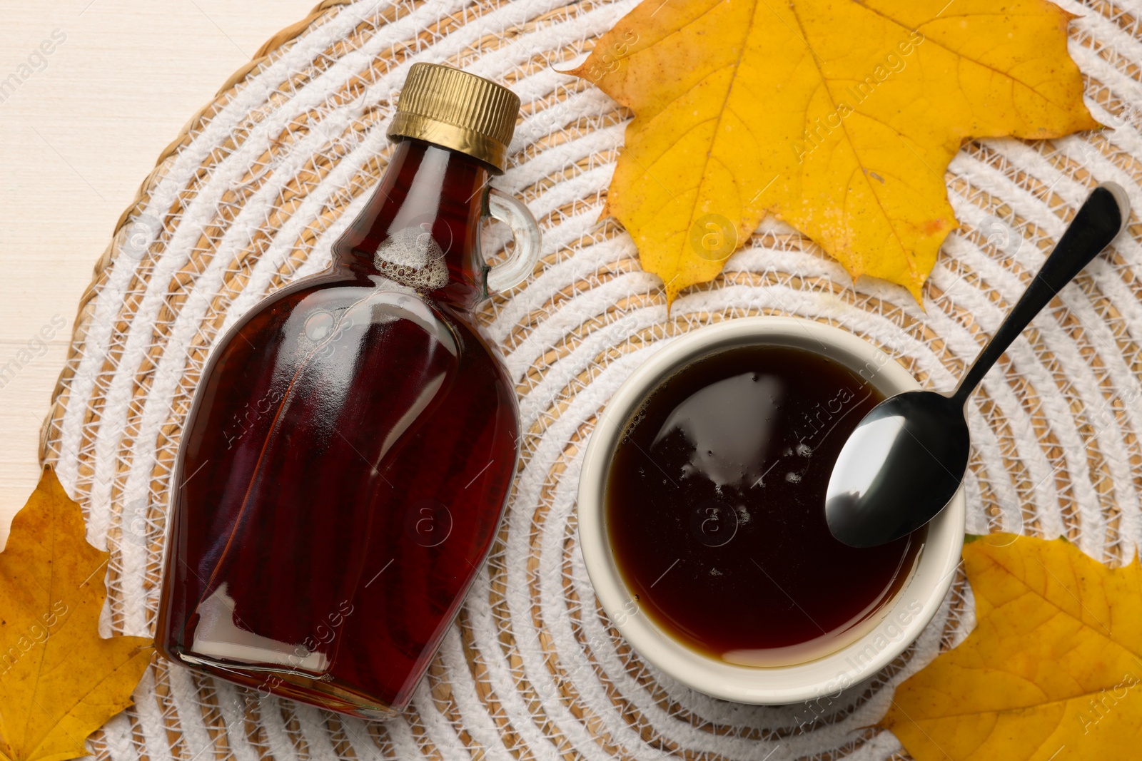 Photo of Flat lay composition of tasty maple syrup and dry leaves on white wooden table