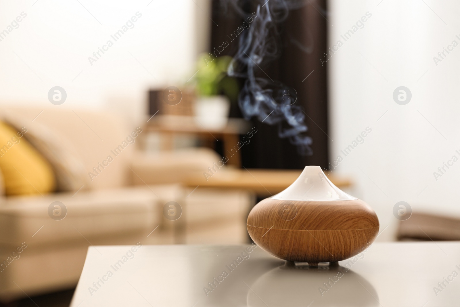 Photo of Aroma oil diffuser on light table at home, space for text. Air freshener