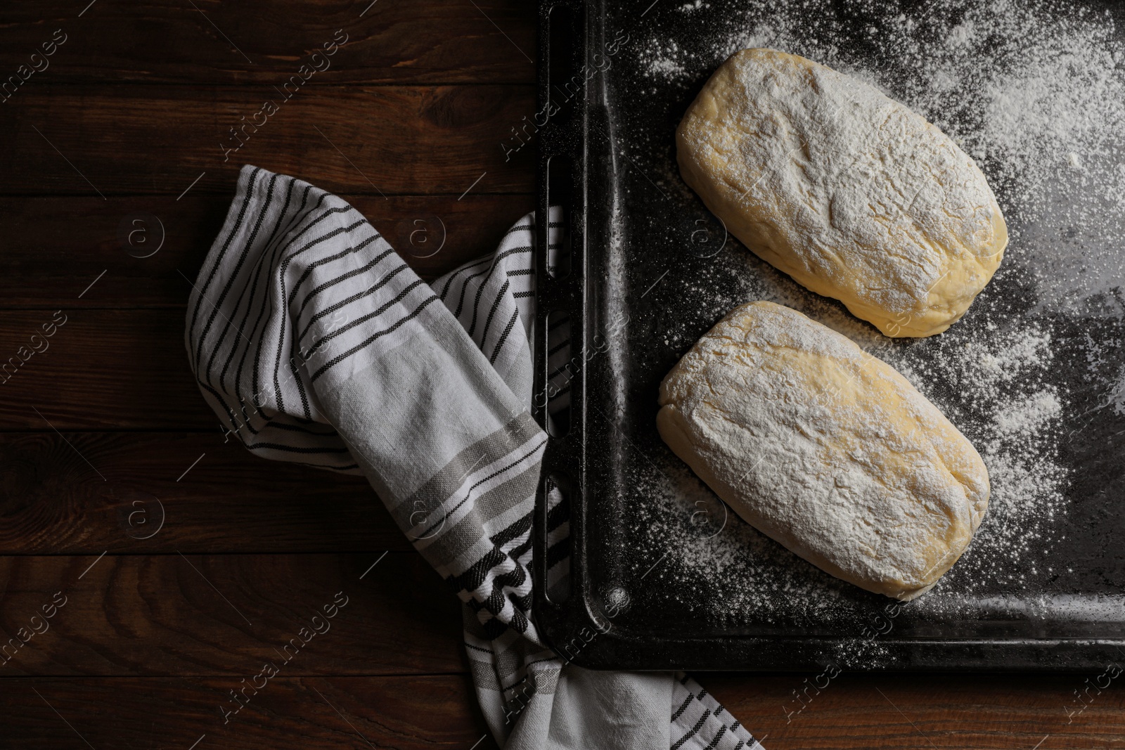 Photo of Raw dough and flour on wooden table, flat lay. Cooking ciabatta