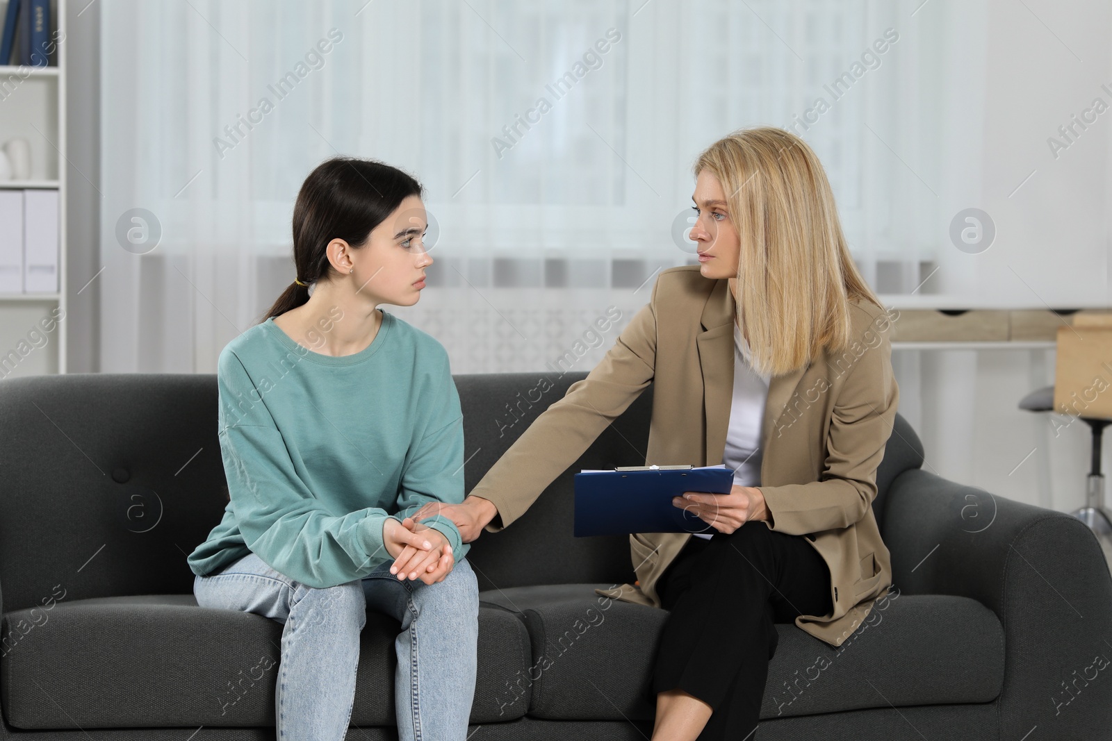 Photo of Psychologist working with teenage girl in office. Teenager problems