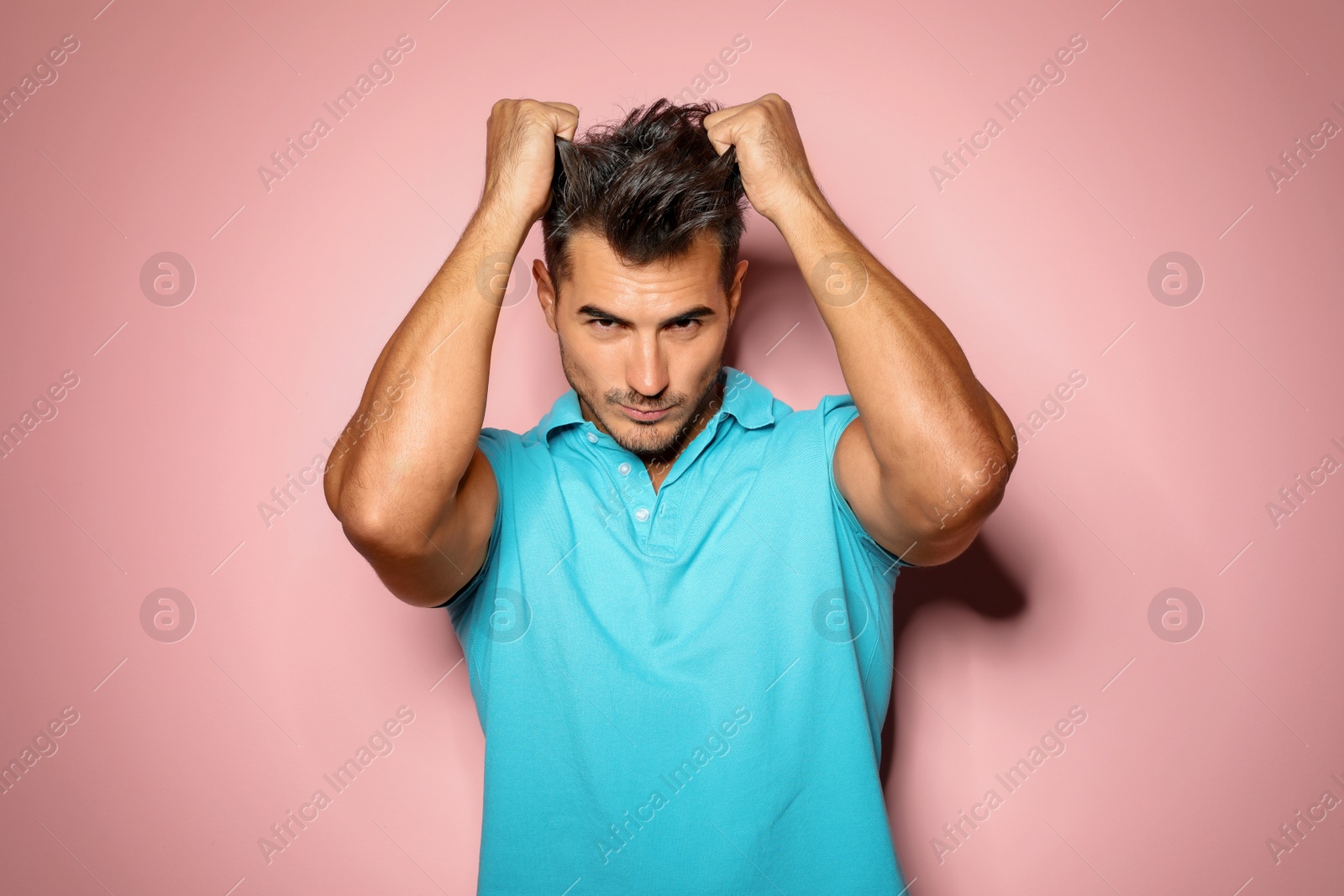 Photo of Young man with trendy hairstyle posing on color background