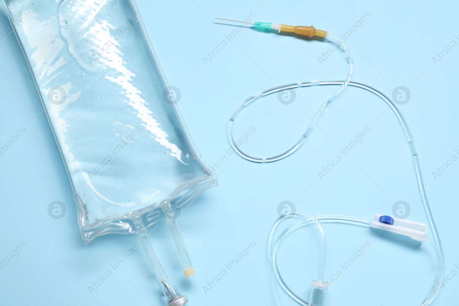 Photo of IV infusion set on light blue background, top view