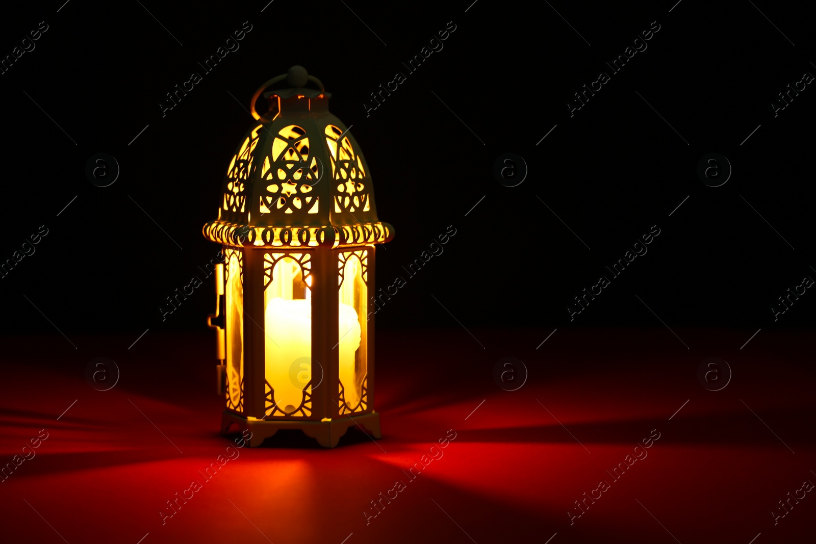 Photo of Decorative Arabic lantern on table against dark background. Space for text