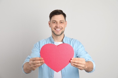 Photo of Portrait of man with decorative heart on light background