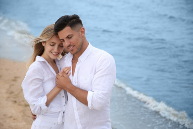 Happy couple on beach, space for text. Romantic walk