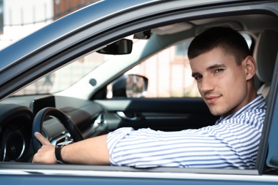 Photo of Attractive young man in modern luxury car