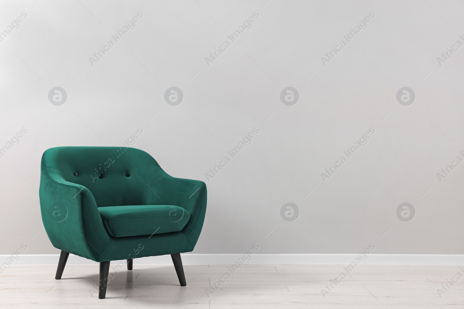 Photo of Comfortable armchair near light grey wall indoors. Space for text