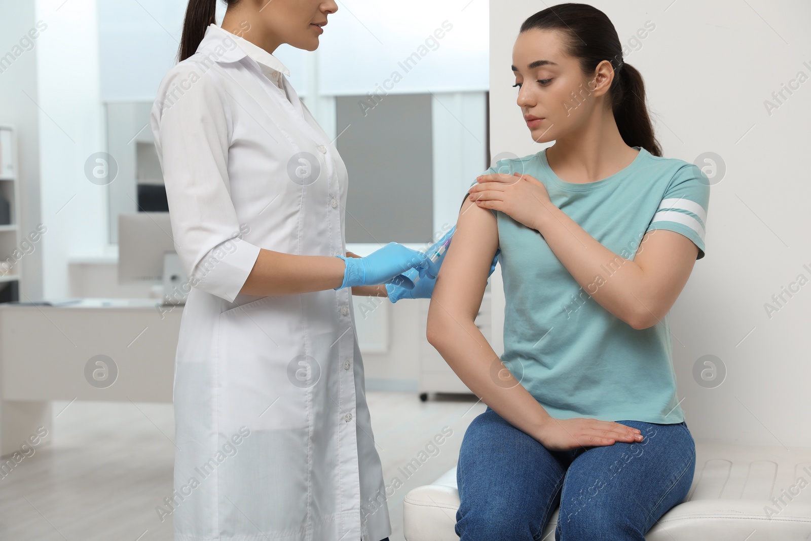 Photo of Doctor giving hepatitis vaccine to patient in clinic