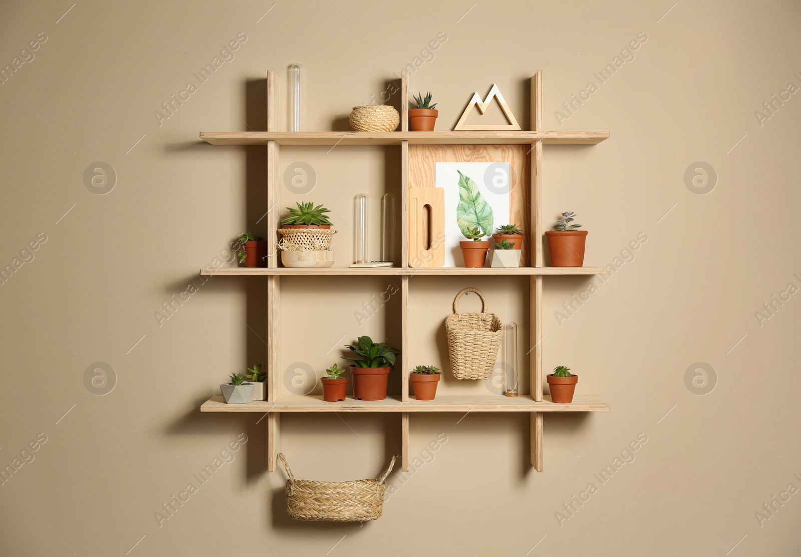 Photo of Wooden shelves with different decorative elements on beige wall