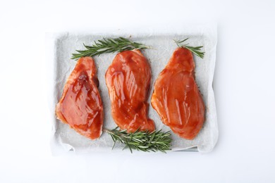 Raw marinated meat and rosemary on white background, top view
