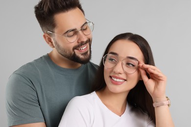 Beautiful couple wearing glasses on light gray background