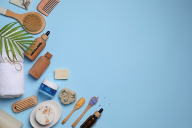 Photo of Flat lay composition with different spa products and tropical leaf on light blue background. Space for text