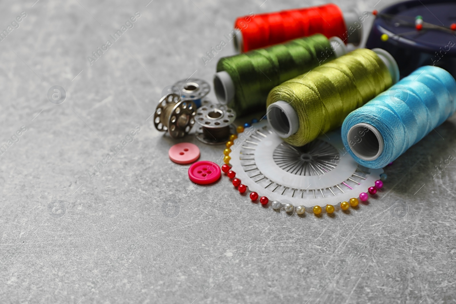 Photo of Composition with threads and sewing accessories on grey background