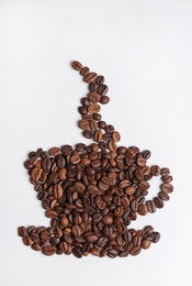 Cup made of roasted coffee beans on white background