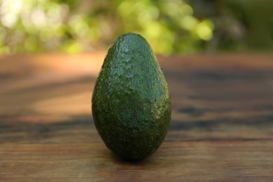 Photo of Fresh avocado on wooden table outdoors, closeup