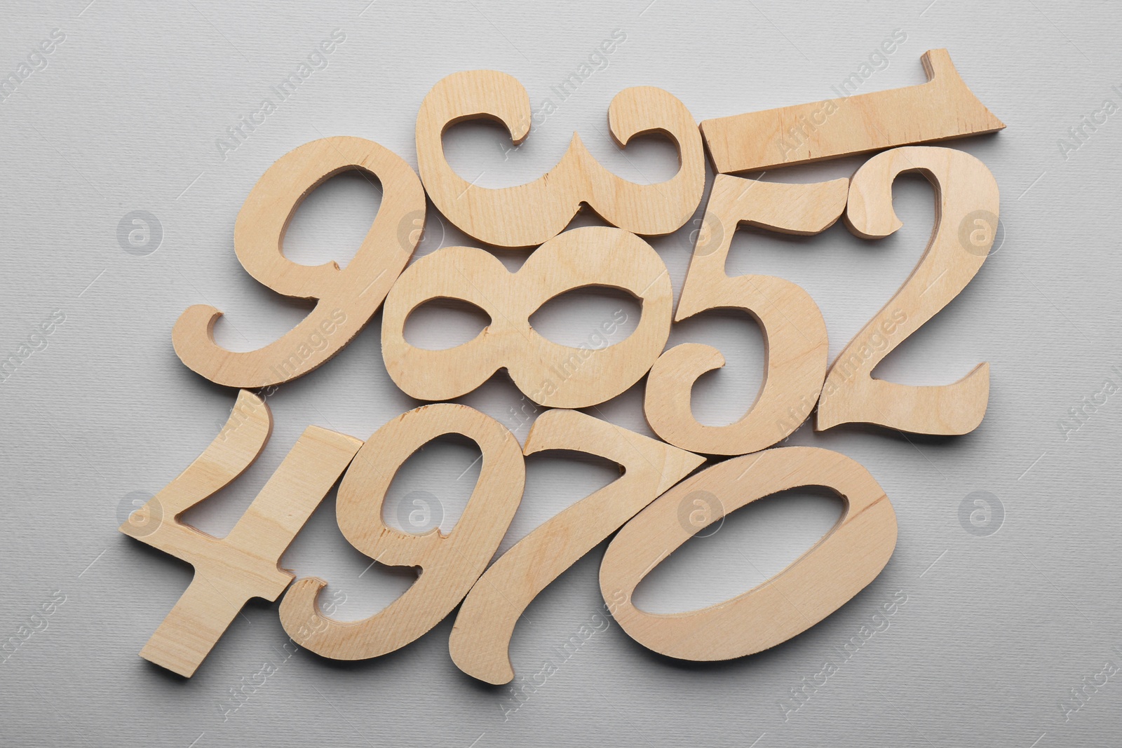 Photo of Wooden numbers on light grey background, flat lay